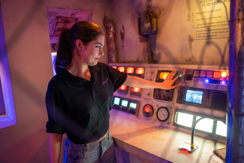 A woman in work attire plays an escape room